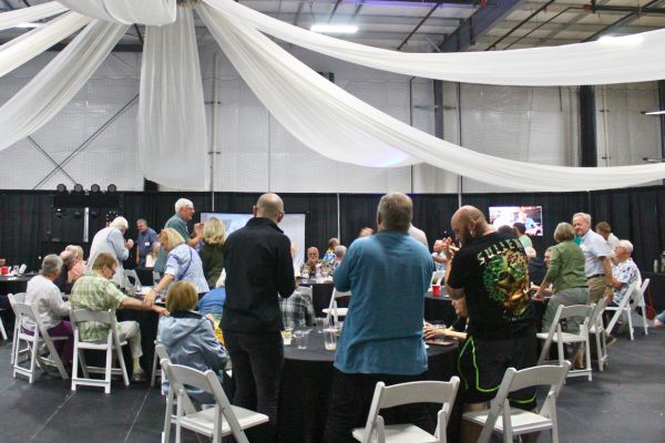 Group of people sitting and standing at tables during a retirement party