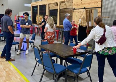 Group of professionals networking near the axe throwing lanes at BGR